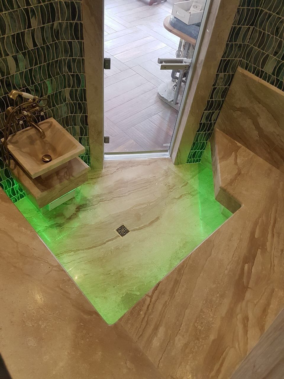 лежак и курна из мрамора в хаммаме с зеленой подсветкой