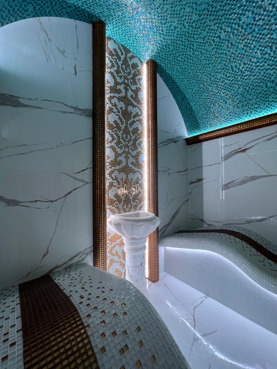 Современный хаммам с подогреваемыми мраморными скамьями и душами